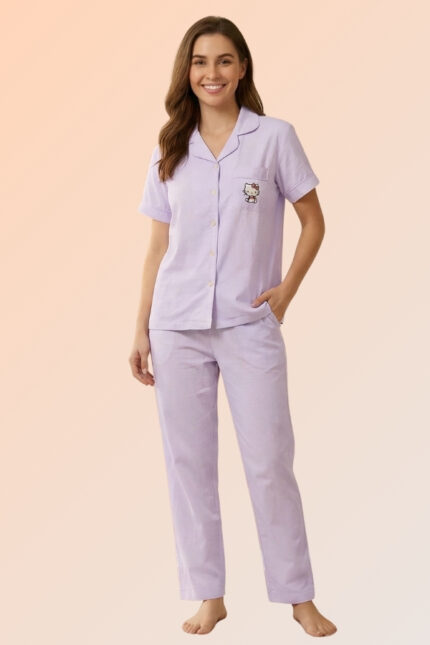 Woman smiling in a lavender 2-piece sleepwear set featuring a cotton brush button-down shirt with a character pocket and long pajama bottoms.