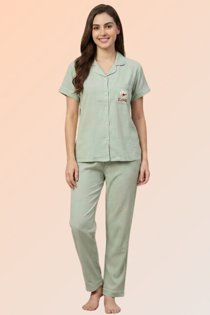 Woman wearing a soothing sage green cotton brush pajama set with a heart pocket shirt and relaxed-fit long pants.