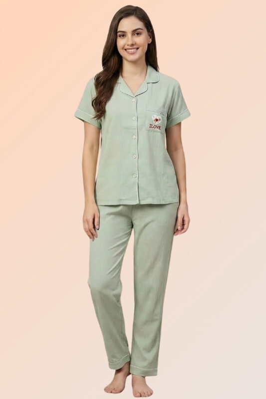 Woman wearing a soothing sage green cotton brush pajama set with a heart pocket shirt and relaxed-fit long pants.
