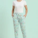 Full-body photo of a model wearing fresh mint green ice cream print women's pajamas with colorful outlines, white drawstring with tassels, and grey slippers.
