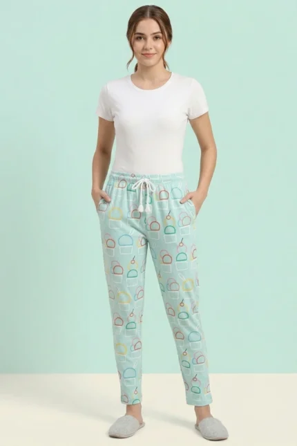 Full-body photo of a model wearing fresh mint green ice cream print women's pajamas with colorful outlines, white drawstring with tassels, and grey slippers.