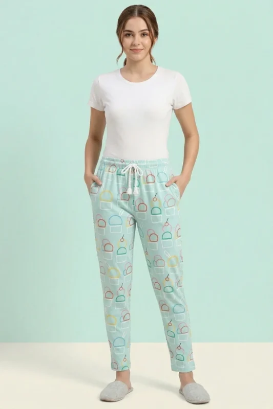 Full-body photo of a model wearing fresh mint green ice cream print women's pajamas with colorful outlines, white drawstring with tassels, and grey slippers.