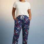 Full-body view of a model in versatile navy blue burst print women's pajamas with dynamic colorful shapes, drawstring with tassels, and hands in pockets.