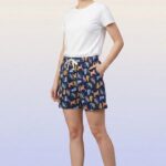 Close-up of navy blue women's shorts with colorful cat pattern and white drawstring.