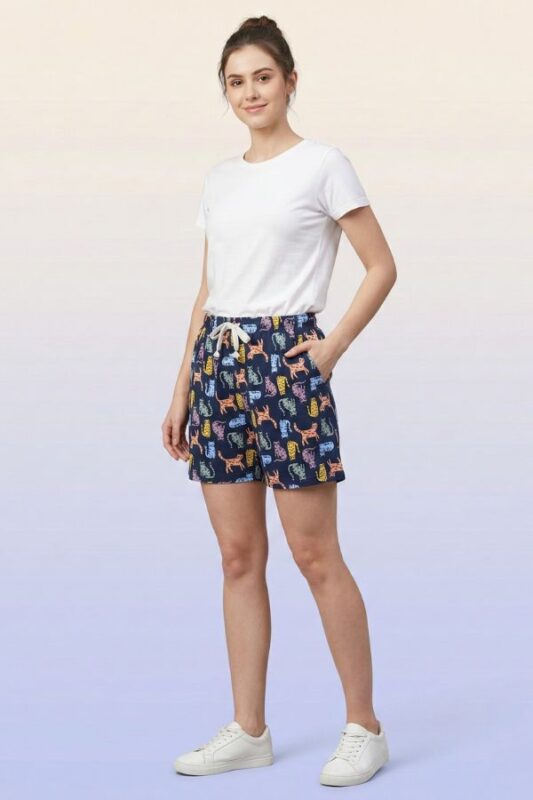 Close-up of navy blue women's shorts with colorful cat pattern and white drawstring.