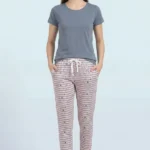Full-body view of a model in versatile striped and star-sprinkled women's pajamas in grey with small stars, drawstring with tassels, and sneakers.