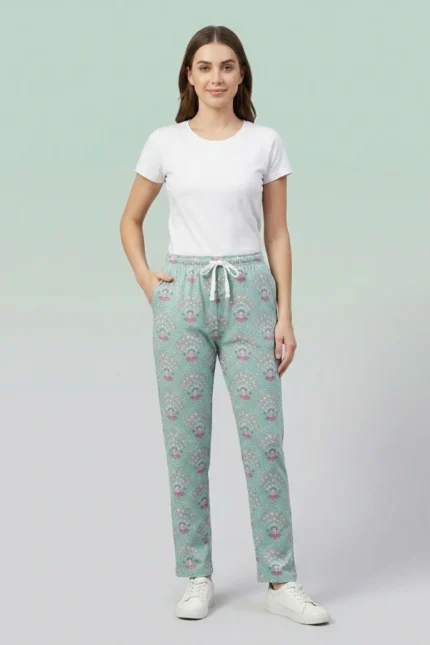 Full-body image of a model wearing elegant teal mandala print women's pajamas with intricate designs, drawstring with tassels, and hands in pockets.