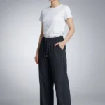 Side profile of a model wearing black wide-leg Korean lounge pants with elastic drawstring waist and pockets.