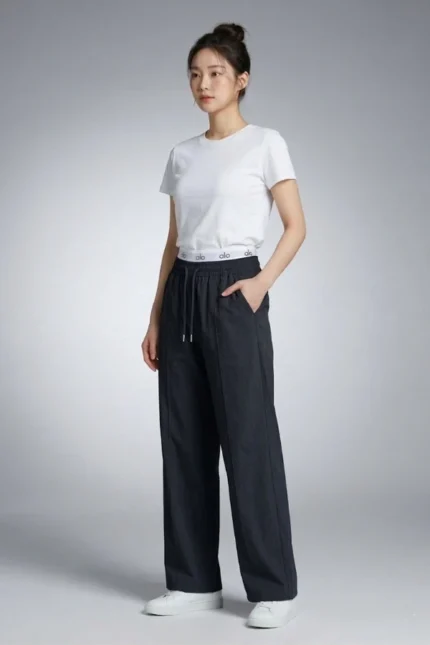 Side profile of a model wearing black wide-leg Korean lounge pants with elastic drawstring waist and pockets.