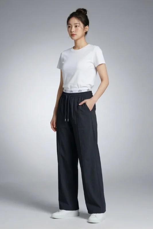Side profile of a model wearing black wide-leg Korean lounge pants with elastic drawstring waist and pockets.