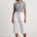 Female model wearing a classic white cotton capri pants with a grey short-sleeve sweater.