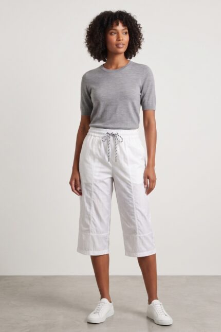 Female model wearing a classic white cotton capri pants with a grey short-sleeve sweater.