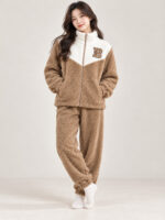 Woman wearing a brown and cream plush winter co-ord set with a zip-front top and matching pyjamas