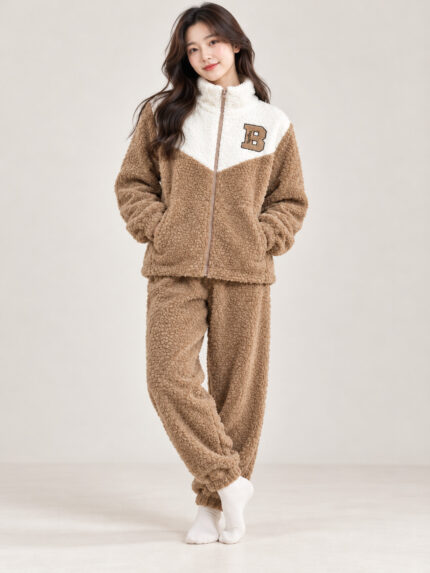 Woman wearing a brown and cream plush winter co-ord set with a zip-front top and matching pyjamas